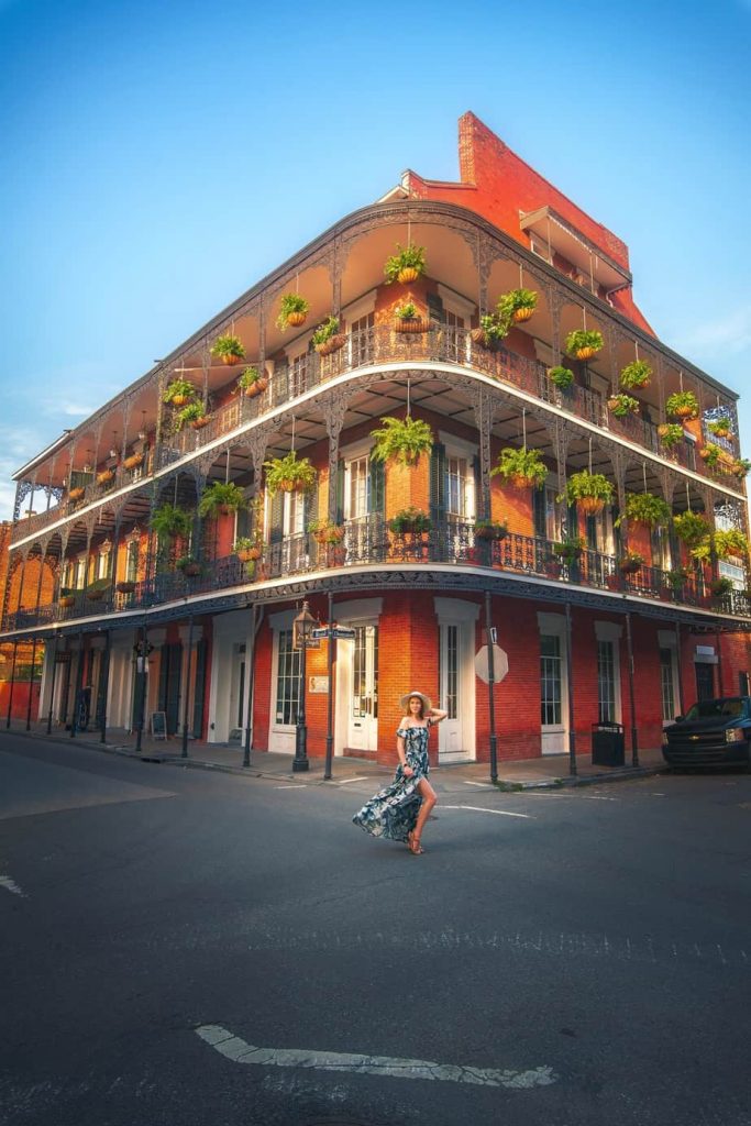 woman standing in front of balcony in new orleans at sunset