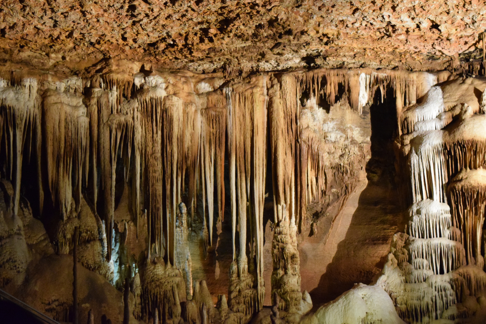 interior of a cavern with formations lit up by manmade lighting. the caverns are brown and white inside