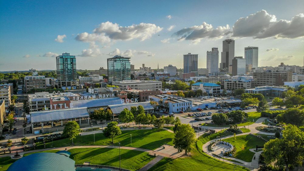 Aerial view of the Little Rock River Market District with green grass and blue sky with clouds