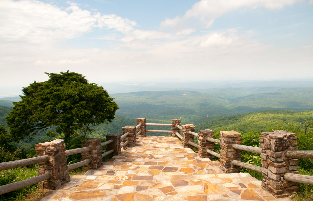 One of the overlooks at Mount Magazine State Park with brown stone overlooking green mountains