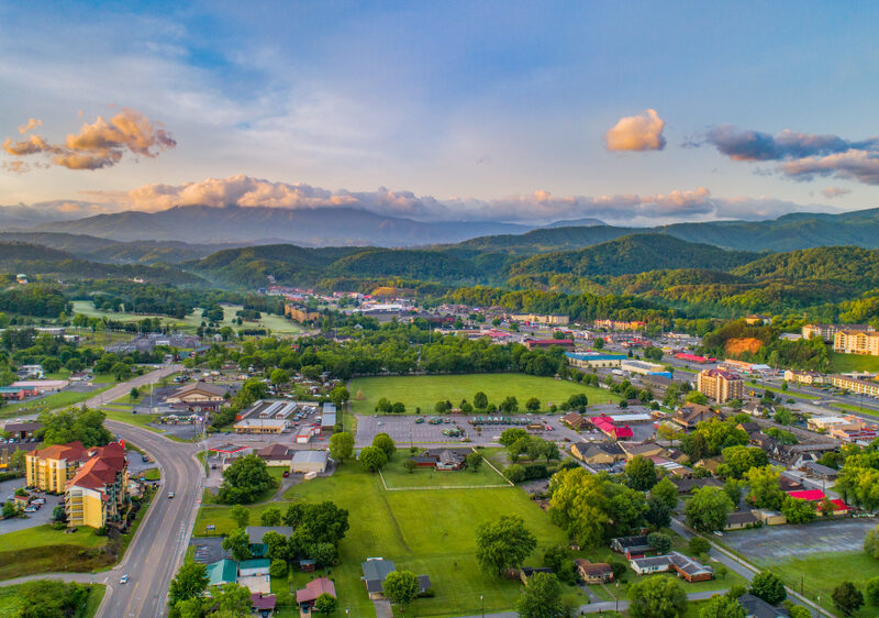 Aerial view of Pigeon Forge surrounded by mountains at sunset.
