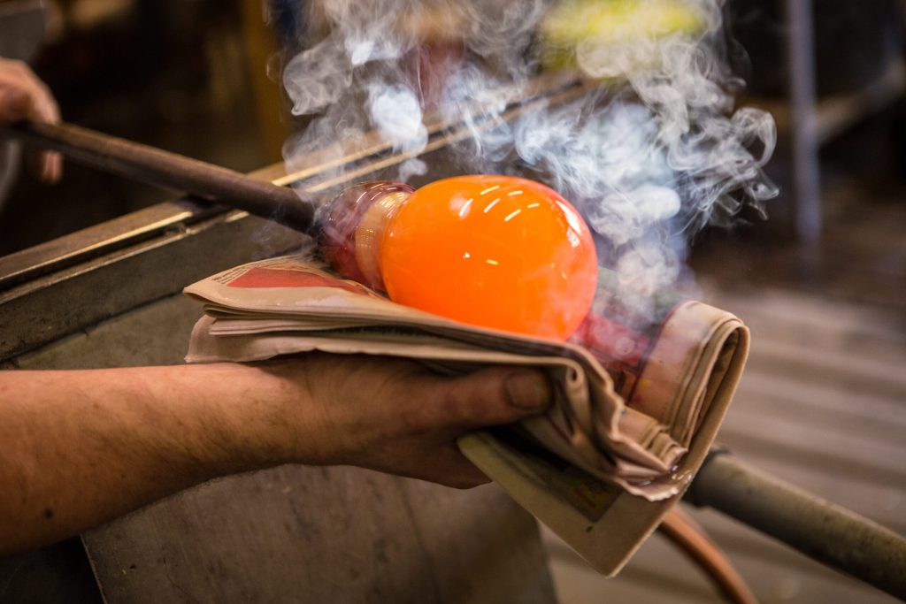 Photo of a person blowing glass.