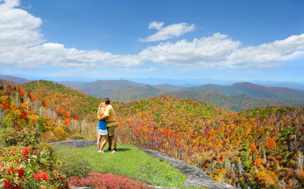 A couple looking out at a mountain range in the fall