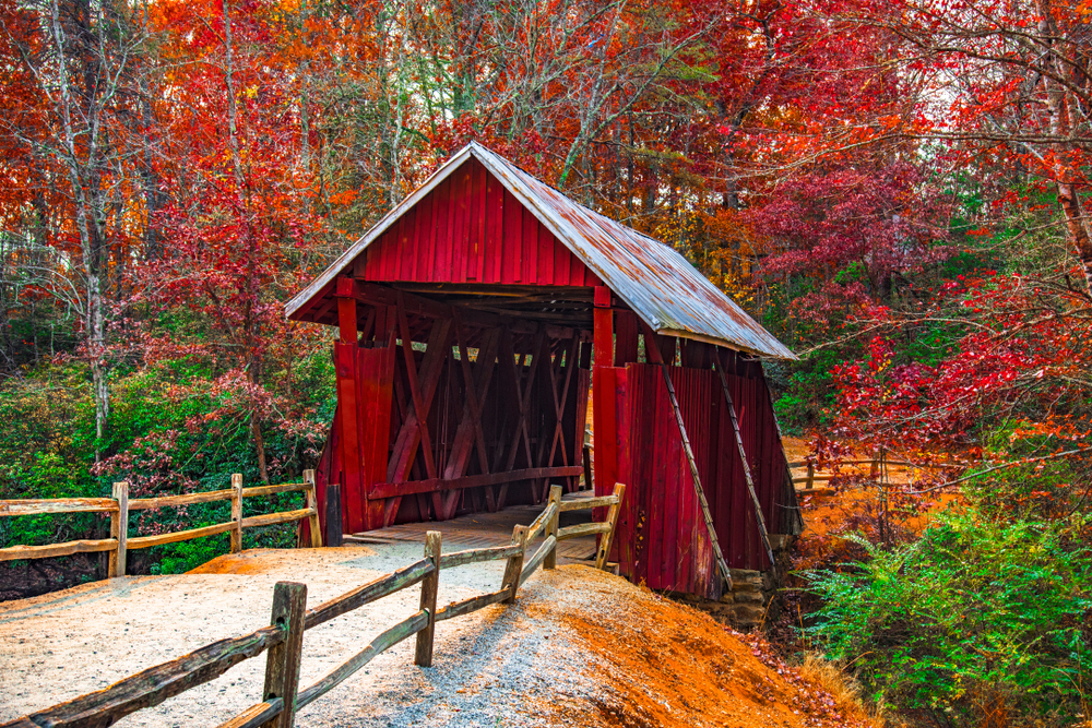 Campbells Covered Bridge which is a covered bridge that is painted bright red in the fall surrounded by trees with changing leaves one of the best south carolina road trips