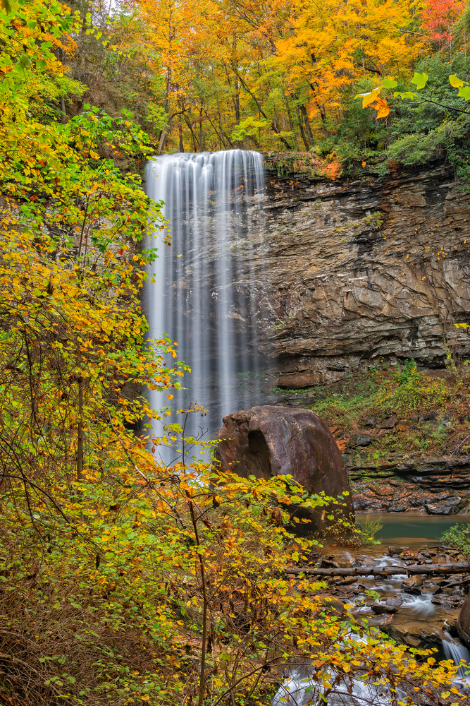 A tall waterfall surrounded by fall foliage at a state Park on a Georgia Fall Foliage road trip