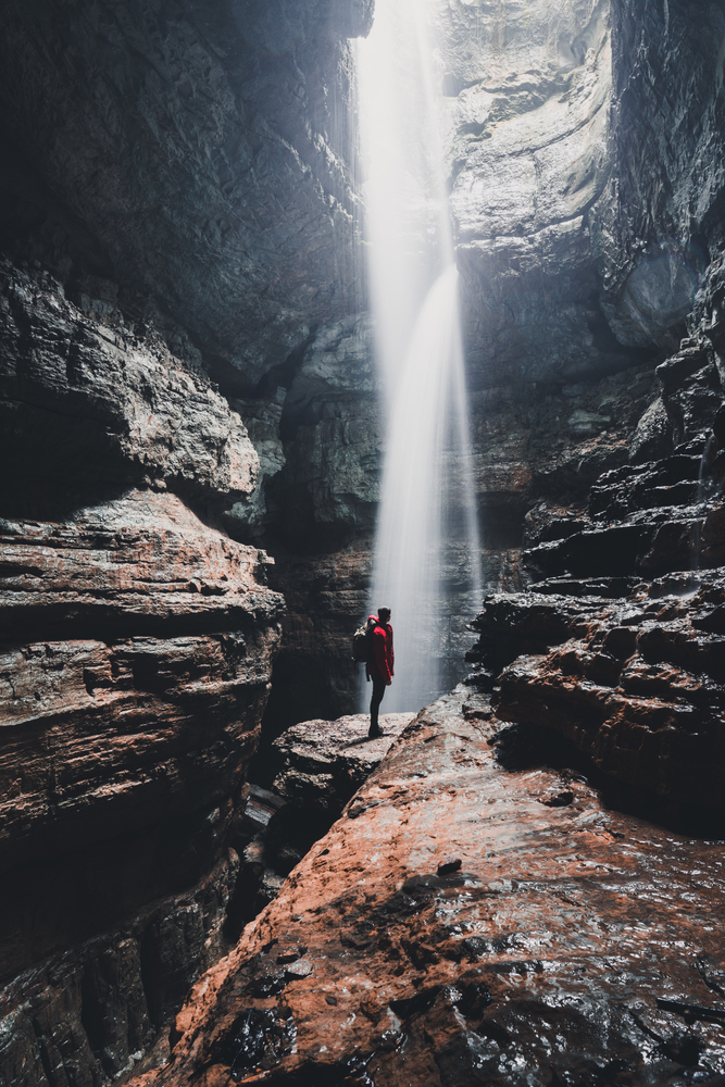 Terrence stands precariously on a rock in the middle of the waterfall cascading in at Stephen Gap, one of the best hidden gems in the South.