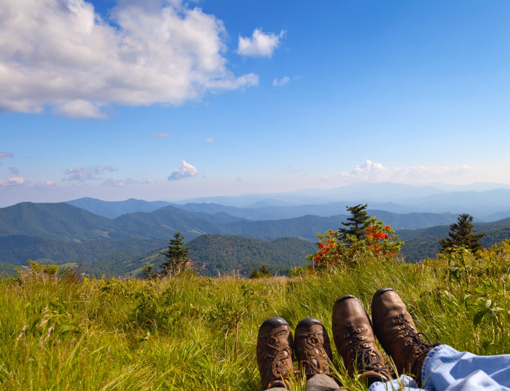 Two travelers rest their weary feet as they relax looking over the view from one of the hidden gems in the south.