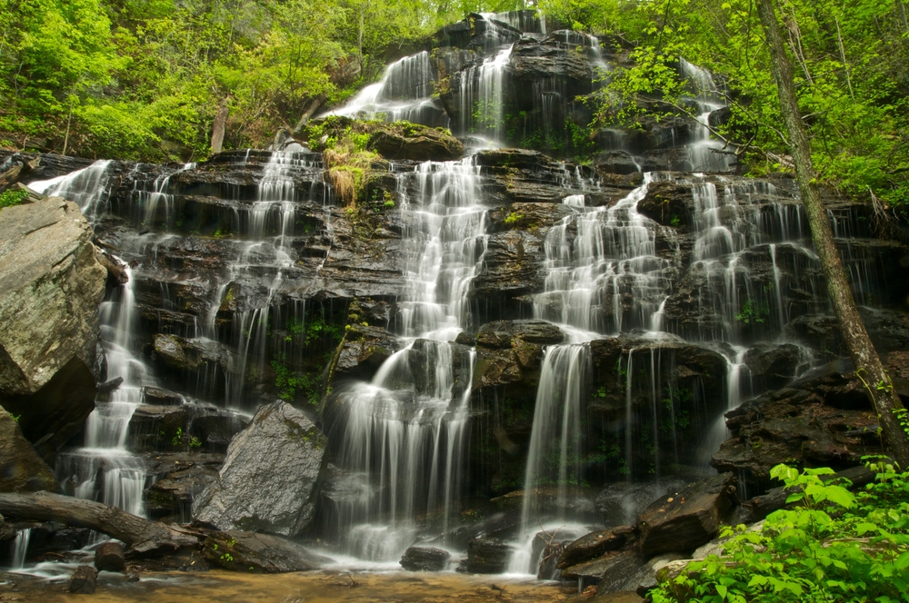 Issaqueena Falls which is a massive cascading waterfall in South Carolina surrounded by greenery one of the best South Carolina road trips