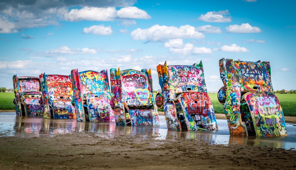 Cadillacs covered in spray paint stick up from the ground on Route 66.