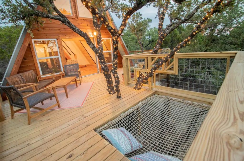 The front deck of a cabin in Texas that has a built in hammock that fits two people one of the coziest cabins in the South