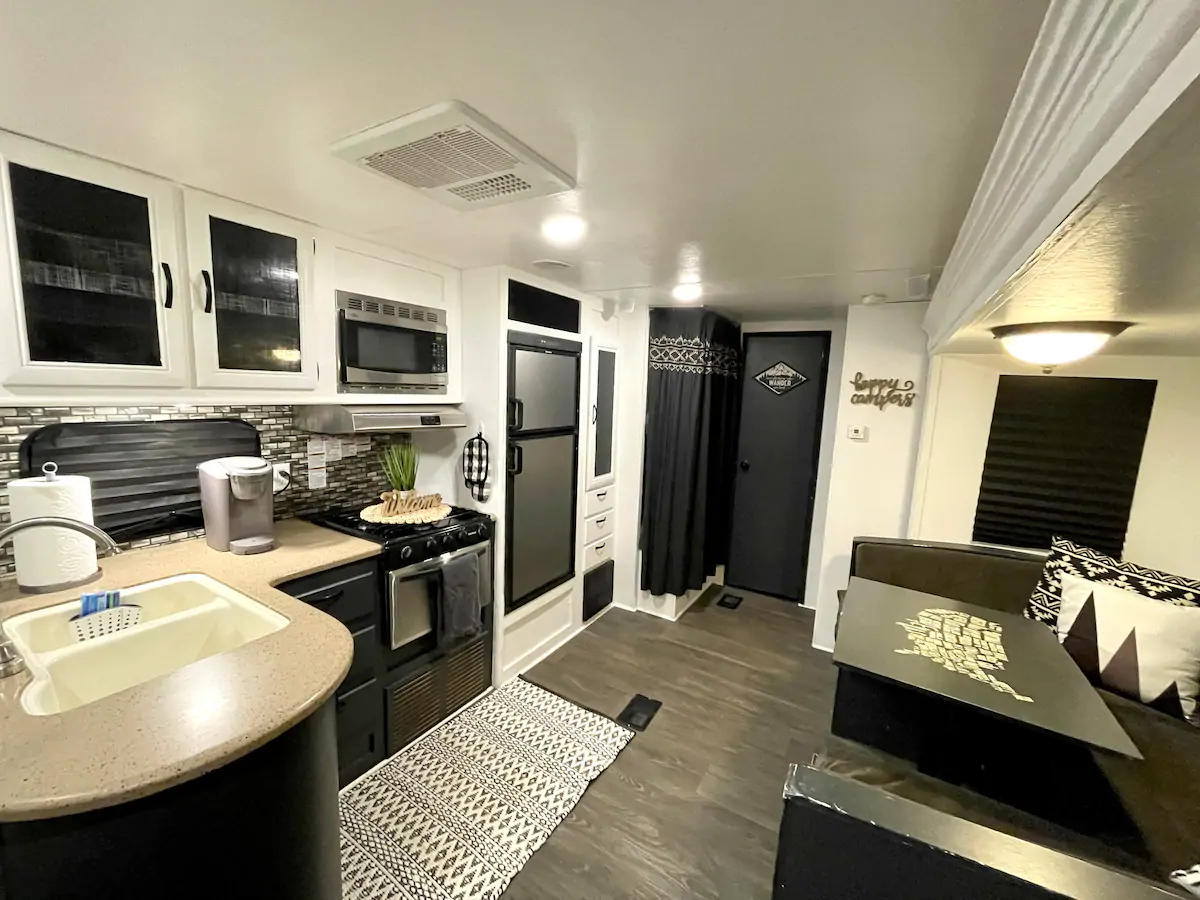 Photo of the black, white, and gray interior of a modern RV Airbnb. 