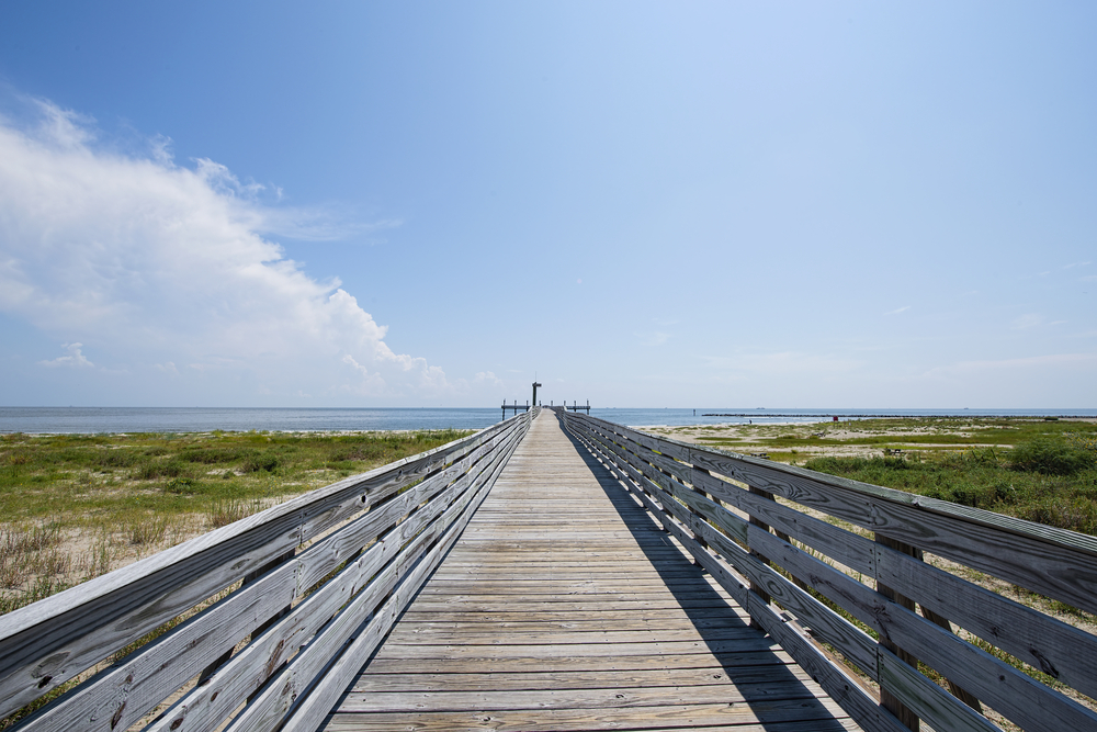 Photo of the boardwalk trail leading to the beach at Grand Isle State Park, one of the best places for hiking in Louisiana.