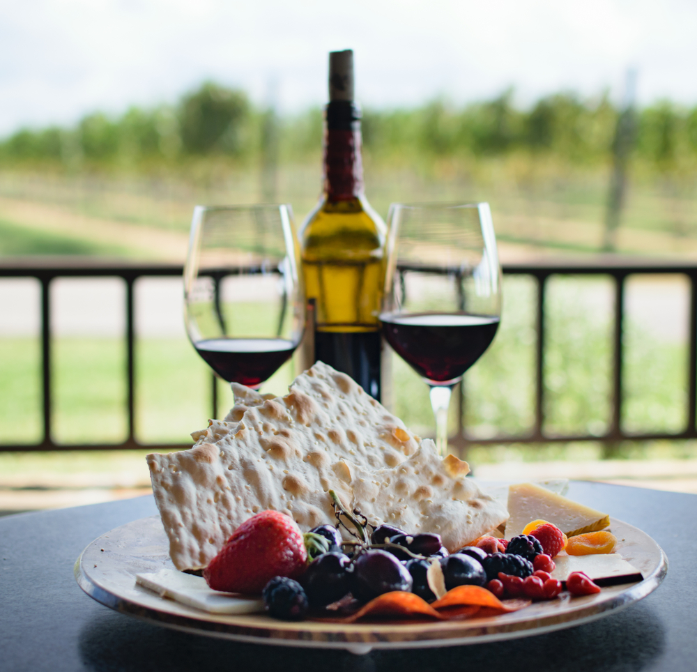 Photo of wine glasses and a plate of cheese and crackers at a winery in Fredericksburg, one of the best weekend getaways in Texas.