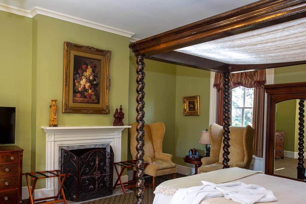 A four poster bed in a green bedroom in a bed and breakfast in savannah