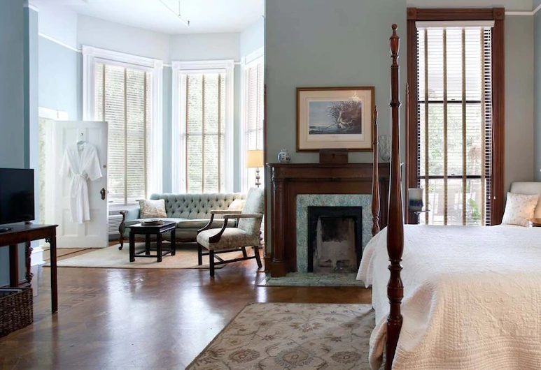 A beautiful wooden fireplace and a four poster bed in a bed and breakfast in savannah