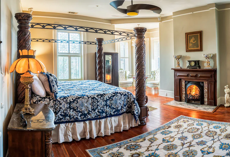 a four poster bed and an open fire in a hotel bedroom in a bed and breakfast in savannah