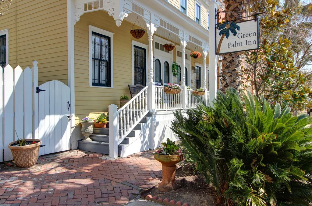 A yellow Victorian building with the Green Palm Inn sign in the foreground in an article about bed and breakfast in savannah
