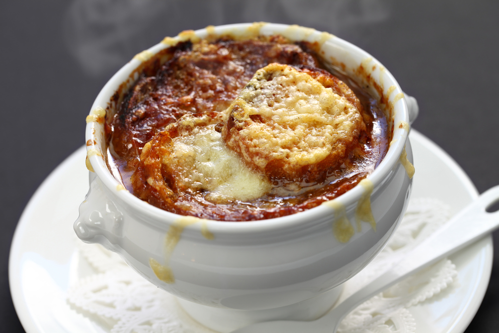 A bowl of French onion soup in a white bowl