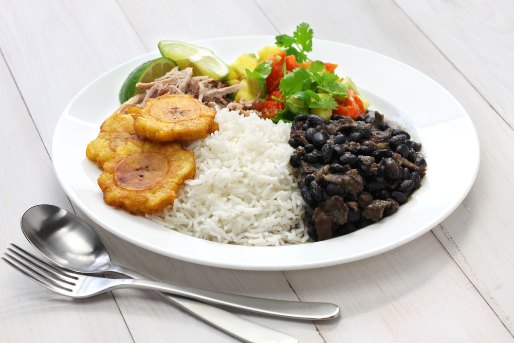 A plate of rice, black beans, fried plantains, and fresh salsa one of the best black owned restaurants in New Orleans