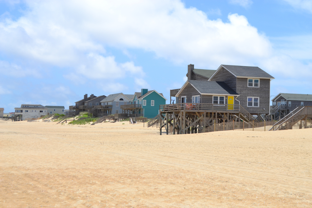 Beach houses next to wide beach in the Outer Banks.