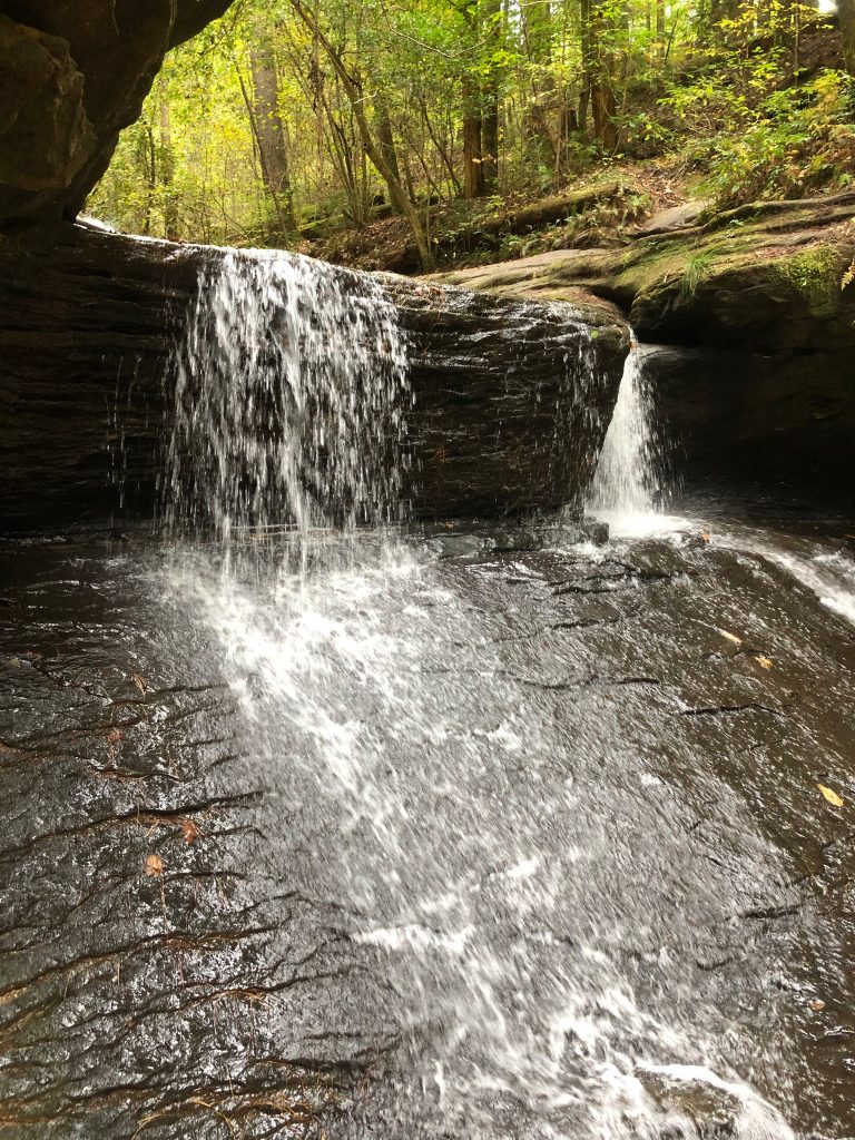 Copperas Falls flows over a black rock in Kentucky.