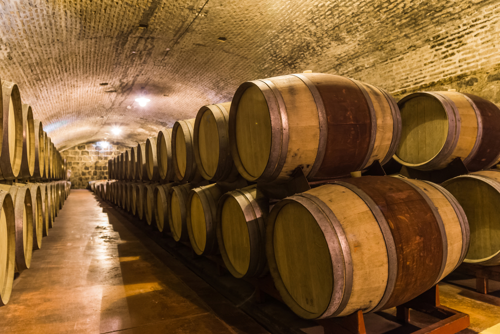 Oak wine barrels stacked up in a caller in a post about wineries in the south