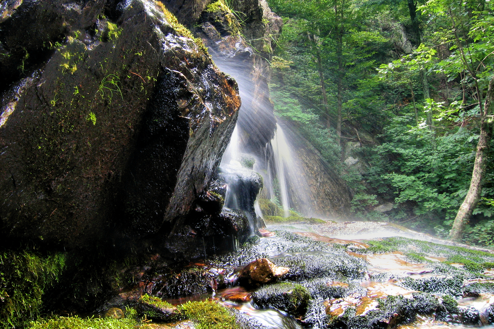 A photo of water spraying from the bottom of a waterfall on Apple Orchard Falls Trail, one of the best Blue Ridge Parkway hikes.