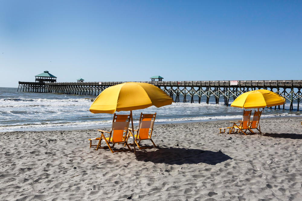 Photo of beach chairs and umbrellas on a beach near Charleston, South Carolina, one of the best day trips from Savannah.