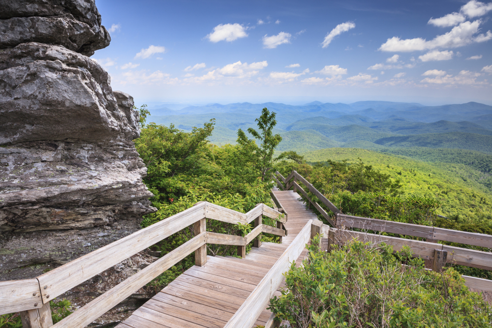 A photo of an overlook with a view of mountains on the Tanawha Trail, one of the most scenic Blue Ridge Parkway hikes.