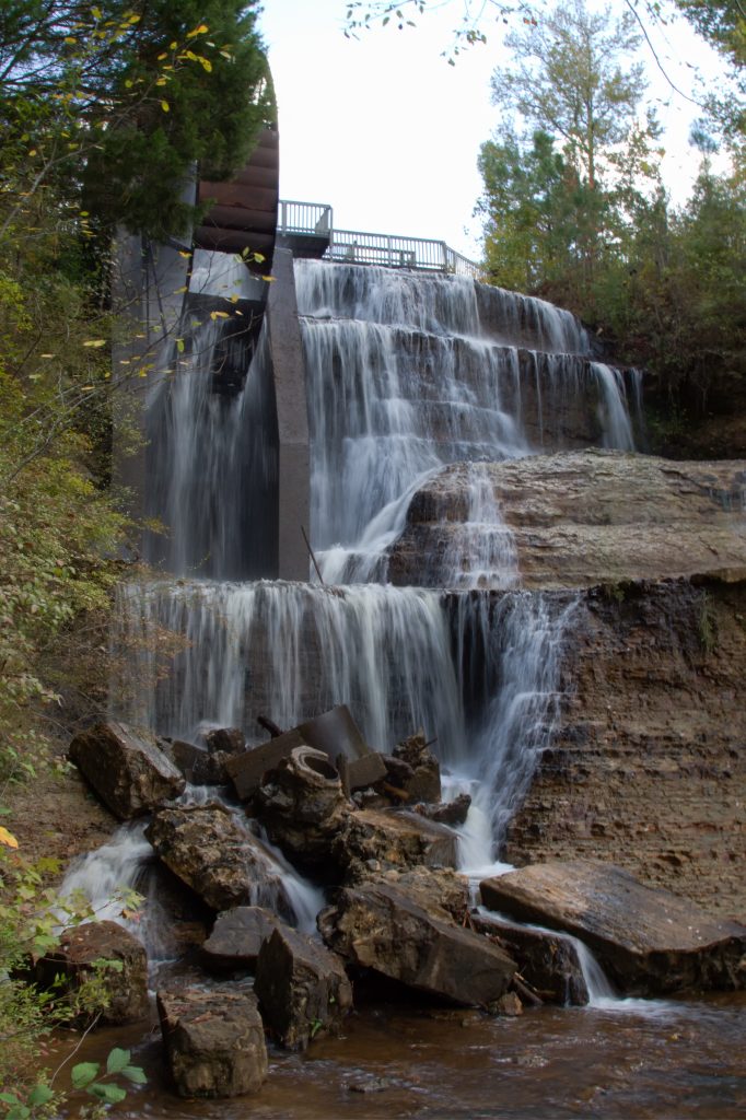 Waterfall in Mississippi over cascading boulders attached to an old water mill.