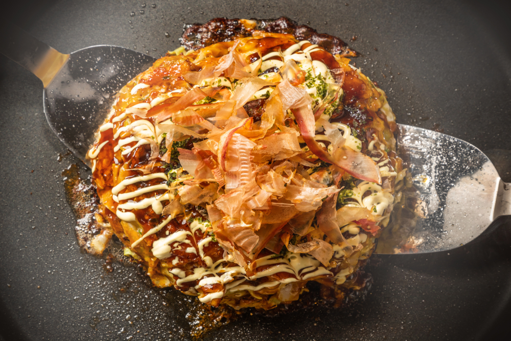 a bao biscut with a lot of toppings on a griddle