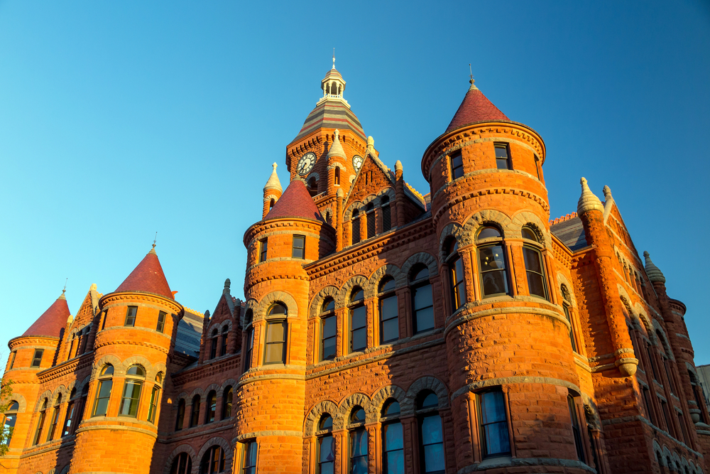 A sunlit red bricked castle at sunset 