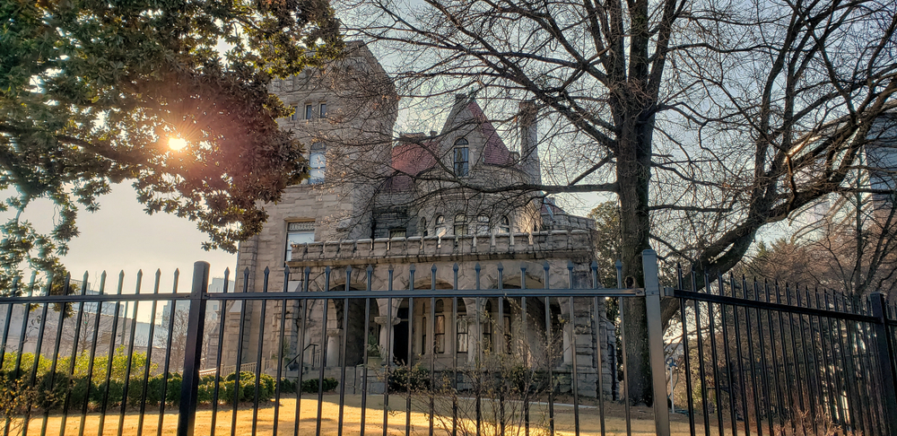 Photo of the Castle on Peachtree with ominous trees almost blocking it from view. 