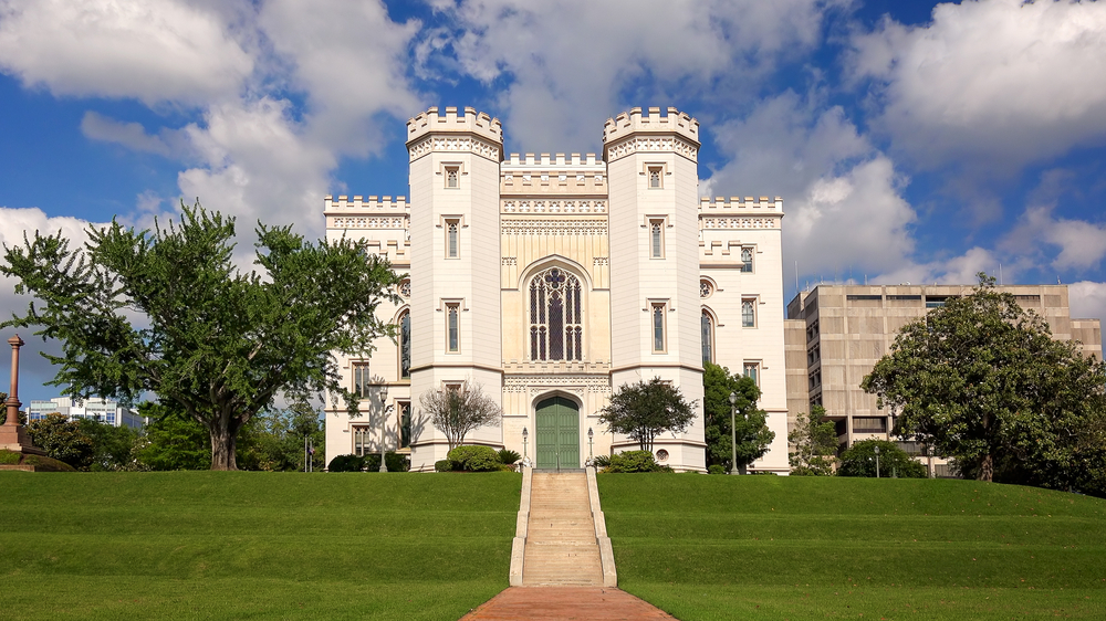 Photo of the Old Capitol Building with its iconic two round turrets and large front stained glass window.