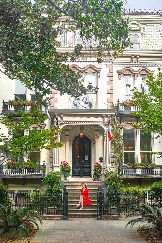 woman sitting in a red dress on the steps of a building in savannah GA