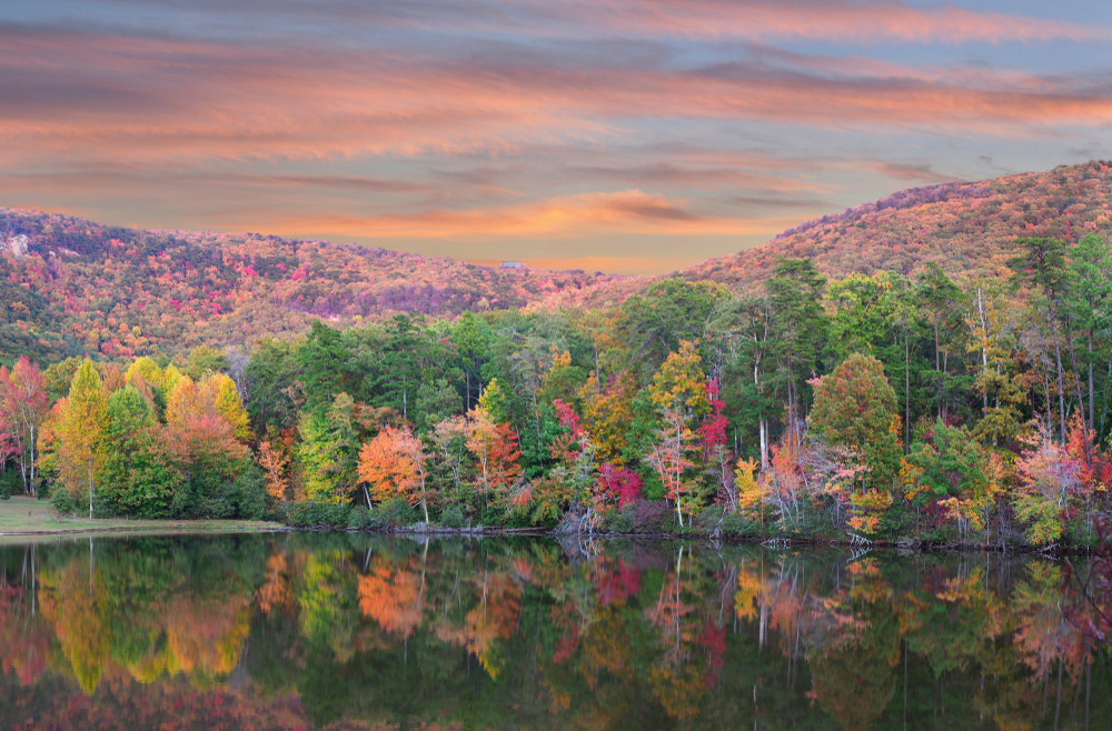 A still lake reflects the bright oranges, reds, and yellows of the autumn colors in Cheaha State Park. 