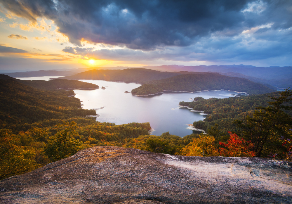 Photo of a sunset over Lake Jocasse, one of the prettiest places during fall in South Carolina, surrounded by fall foliage.