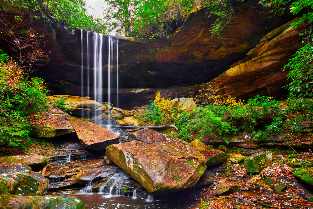 Photo of Van Hook Falls flowing over a small rock cliff into a small creek below.