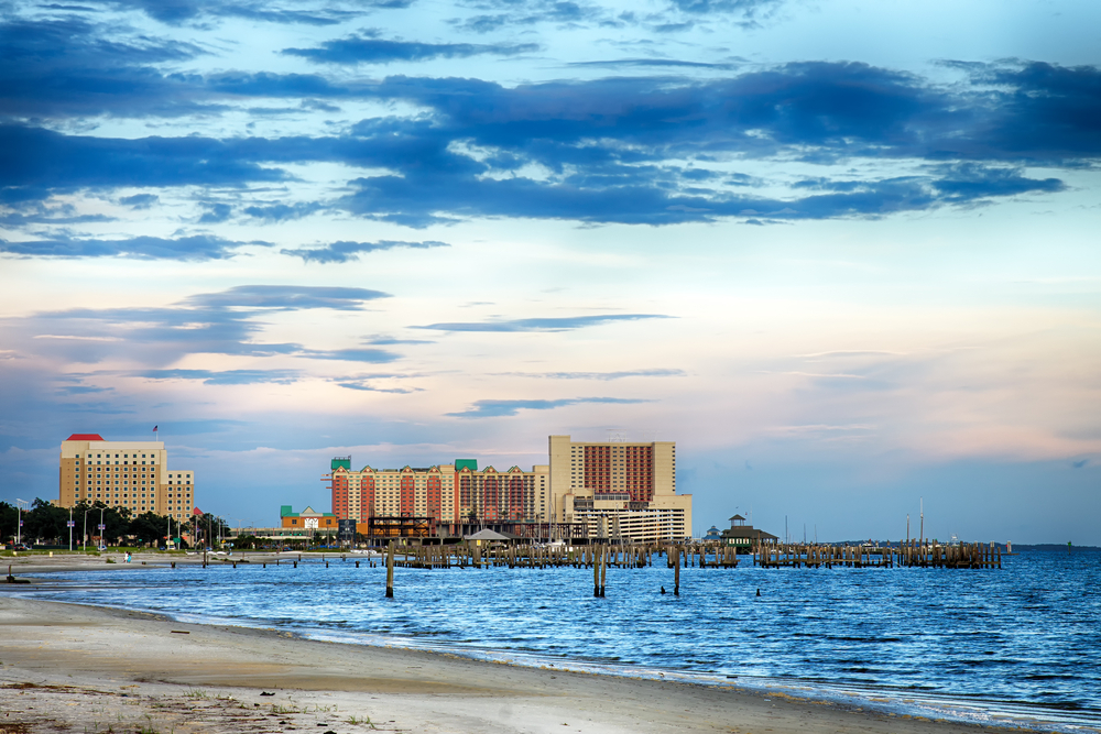 sandy beach and water with buildings in the background