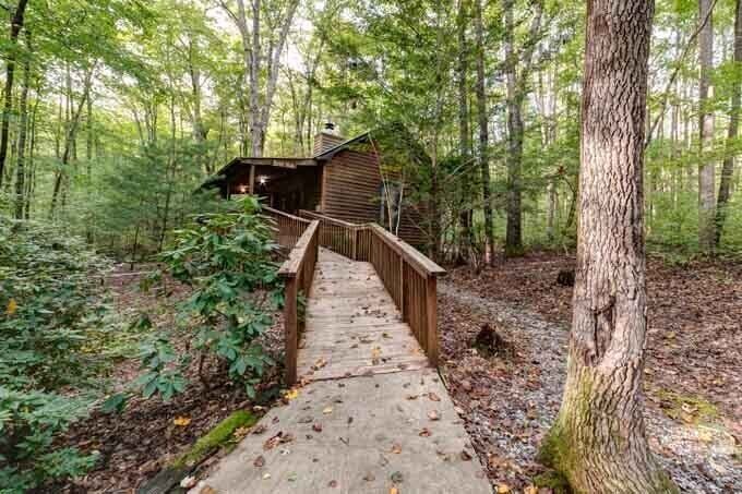 A cabin in the woods with a walkway.