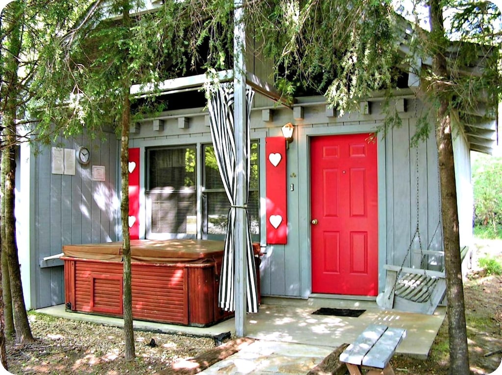 A grey cabin with a red door