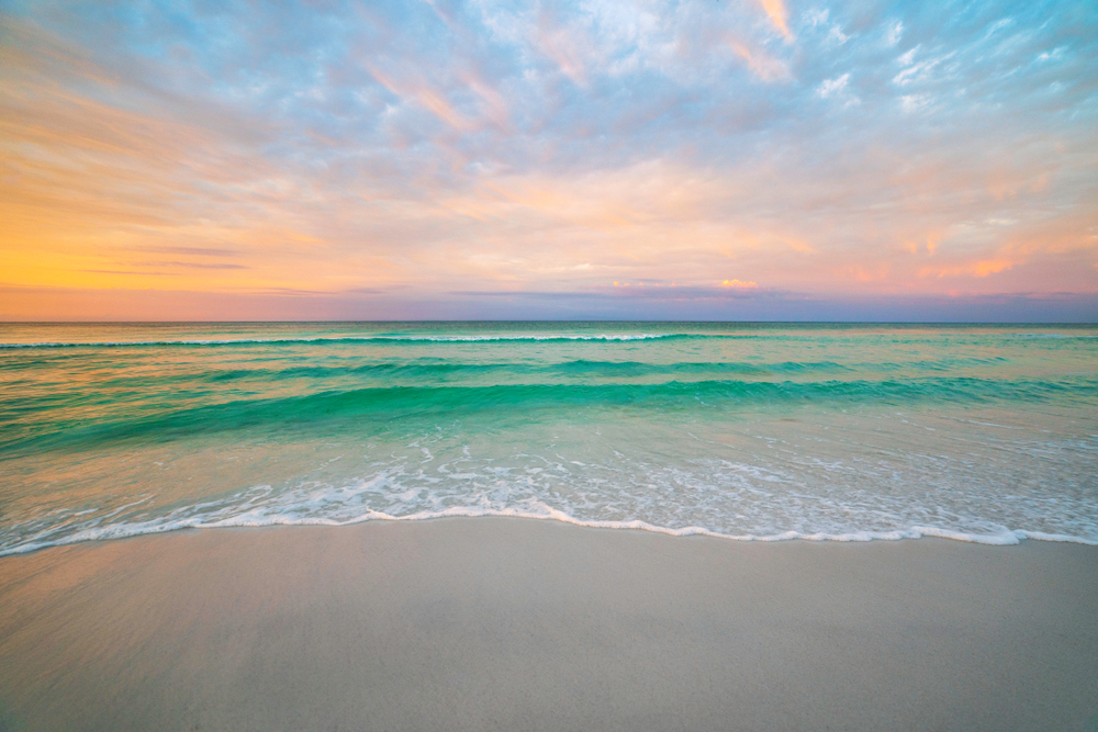 pristine beach in florida at sunset with blue water