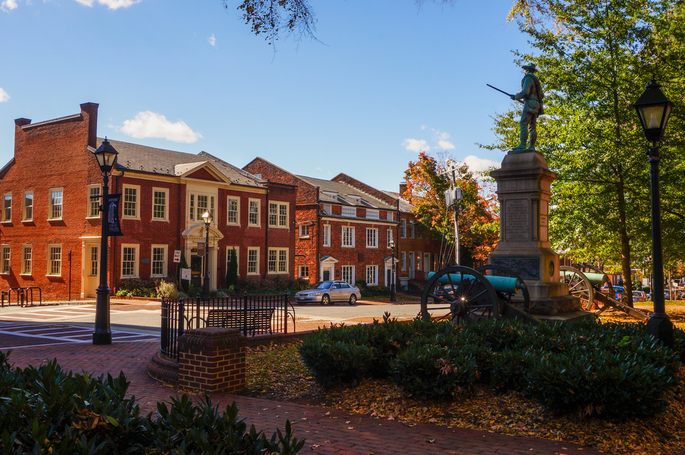 A statue in a park surrounded by old buildings in an article about small towns in Virginia