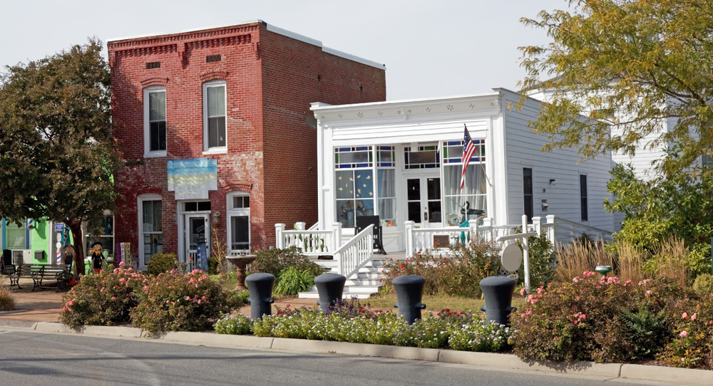 An old red brick building and a white building in the small town Chincoteague