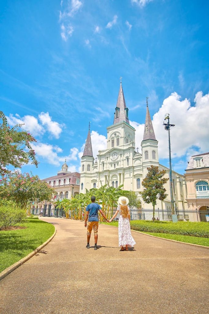 Two people holding hands in front of a church in the French quarter