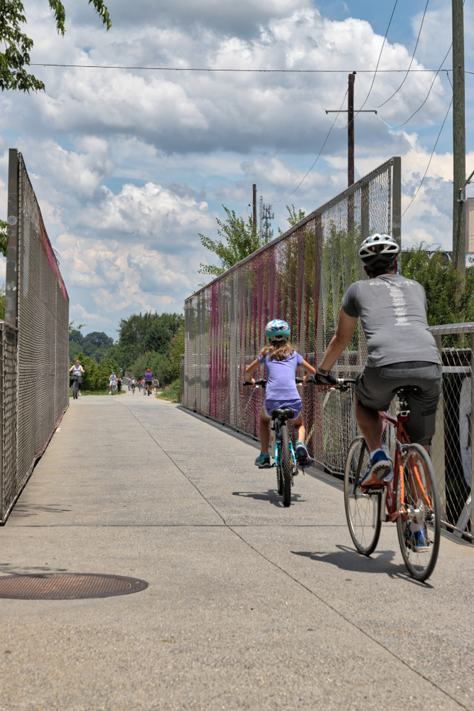 A father and daughter biking along the Beltline path in Atlanta, 