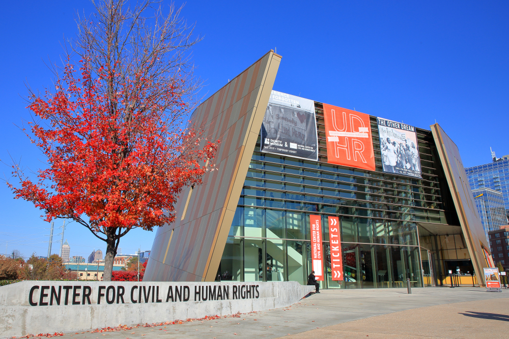 THe outside of the building for the center for Civil and Human Rights with a beautiful red tree. A must visit for any weekend in Atlana