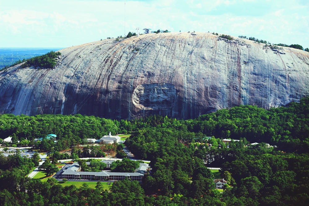 Stone Mountain is a large granite faced mountain where you can see carving of figures coming out of the trees below