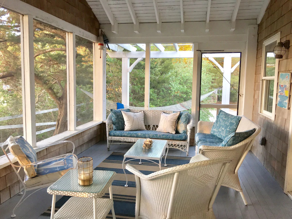Photo of wicker patio furniture on the screened in porch of the Little House on the Ferry, one of the best Outer Banks vacation rentals.