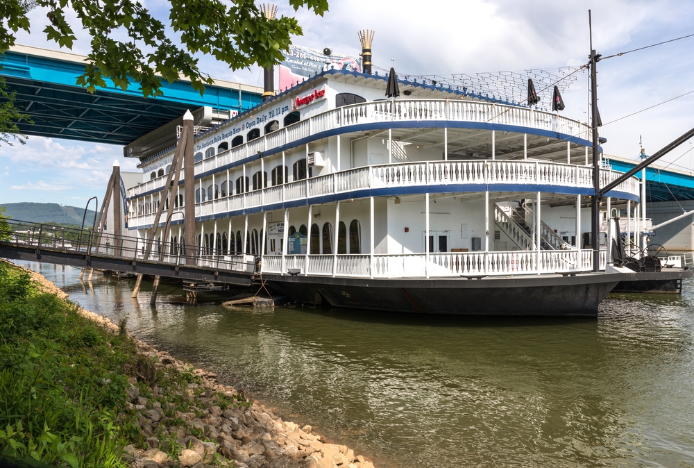 A photo of the Southern Belle Riverboat docked at the Tennessee River on a cloudy day.